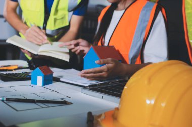 Endüstriyel mühendislerden oluşan bir ekip, fabrikadaki masada bulunan makine planlarını analiz ediyor. Fabrikada ya da üretim tesisinde çalışıyorum..