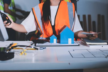 Endüstriyel mühendislerden oluşan bir ekip, fabrikadaki masada bulunan makine planlarını analiz ediyor. Fabrikada ya da üretim tesisinde çalışıyorum..