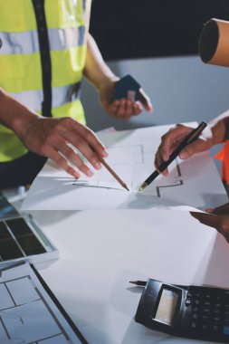 Endüstriyel mühendislerden oluşan bir ekip, fabrikadaki masada bulunan makine planlarını analiz ediyor. Fabrikada ya da üretim tesisinde çalışıyorum..