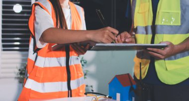 Endüstriyel mühendislerden oluşan bir ekip, fabrikadaki masada bulunan makine planlarını analiz ediyor. Fabrikada ya da üretim tesisinde çalışıyorum..