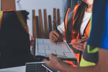 Endüstriyel mühendislerden oluşan bir ekip, fabrikadaki masada bulunan makine planlarını analiz ediyor. Fabrikada ya da üretim tesisinde çalışıyorum..