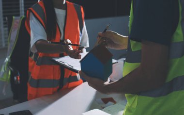 Endüstriyel mühendislerden oluşan bir ekip, fabrikadaki masada bulunan makine planlarını analiz ediyor. Fabrikada ya da üretim tesisinde çalışıyorum..
