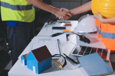 Endüstriyel mühendislerden oluşan bir ekip, fabrikadaki masada bulunan makine planlarını analiz ediyor. Fabrikada ya da üretim tesisinde çalışıyorum..