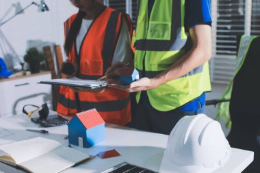 Endüstriyel mühendislerden oluşan bir ekip, fabrikadaki masada bulunan makine planlarını analiz ediyor. Fabrikada ya da üretim tesisinde çalışıyorum..