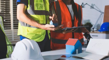 Endüstriyel mühendislerden oluşan bir ekip, fabrikadaki masada bulunan makine planlarını analiz ediyor. Fabrikada ya da üretim tesisinde çalışıyorum..