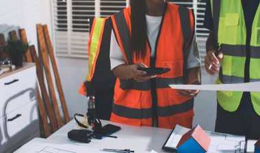 Endüstriyel mühendislerden oluşan bir ekip, fabrikadaki masada bulunan makine planlarını analiz ediyor. Fabrikada ya da üretim tesisinde çalışıyorum..