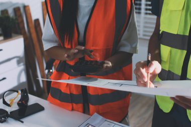Endüstriyel mühendislerden oluşan bir ekip, fabrikadaki masada bulunan makine planlarını analiz ediyor. Fabrikada ya da üretim tesisinde çalışıyorum..