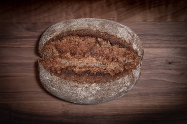 Yukardan aşağı ev yapımı ekşi ekmek kabuğu yükselmiş tahta tahta üzerinde Karanlık stüdyo ortamında vignette ile