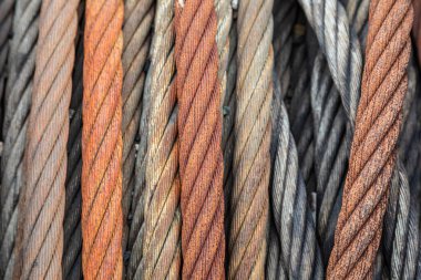 Close-up of old steel cables with varying degrees of rust, from light to heavy corrosion, showing intertwined textures and metallic decay, captured for use as texture or background