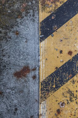 Endüstriyel makine parçalarında siyah ve sarı çizgili makro boya gri-gümüş metal ve pas lekeleri görünür çizikler, dikey bileşim.