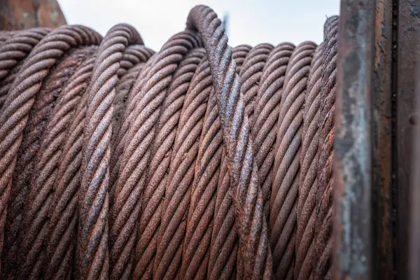 Odaklı paslı metal kabloyla büyük makaranın bir parçası, terk edilmiş tersanede yakın plan.. 