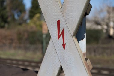 St. Andrew 'un trafik işaretine yakın plan beyaz yüzey ve kırmızı ok sembolü, arka planda bulanık demiryolu izi