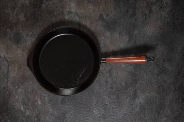 Stüdyonun arka planında, tahta saplı büyük, kullanılmış demir tavanın yukarıdan aşağı görüntüsü.