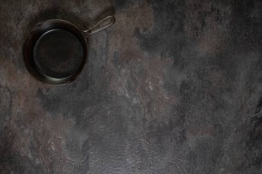 Üst sol köşedeki boş arkaplan üzerine yerleştirilmiş küçük kullanılmış demir tavanın yukarıdan aşağı görünümü