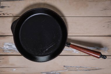 Eski ahşap masa ve kabuğu soyulmuş büyük, kullanılmış demir tavanın tepeden tırnağa yakın çekimi.