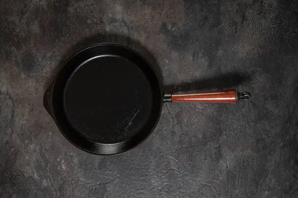 Stüdyonun arka planında, tahta saplı büyük, kullanılmış demir tavanın yukarıdan aşağı görüntüsü.