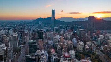 Santiago, Şili 23 Mayıs 2024: İnsansız hava aracı Costanera Center, şehir silueti, San Cristbal Hill ve sıcak günbatımını başkentin üzerinde dikey olarak gösteriyor..