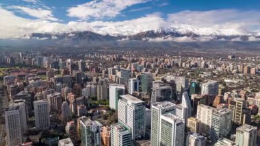 Providencia, Santiago 14 Haziran 2024: Şili 'nin merkezinde kar yağışı sonrası şehrin üzerinde yükselen ve ilerleyen And Dağları' na doğru uçan insansız hava aracı görüntüsü.