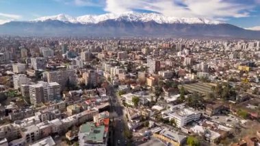 Providencia, Santiago 14 Haziran 2024: Providencia bölgesi üzerinde ilerleyen hava aracı görüntüleri ve arka planda karla kaplı And Dağları.
