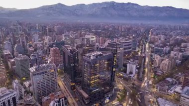 Santiago, Şili 8 Mayıs 2025: İHA güneş doğarken yandan hareket ederek arka planda MUT binasını ve karlı And Dağları 'nı yakalıyor. Sabahın erken saatlerinde şehrin mimarisi ve ufku gelişir..