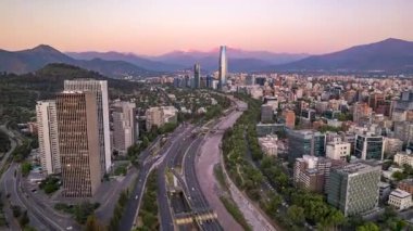 Gün batımında Mapocho Nehri ve Santiago üzerinde Costanera Merkezi ile yan drone yükselişi. Çekim 2024-10-25.