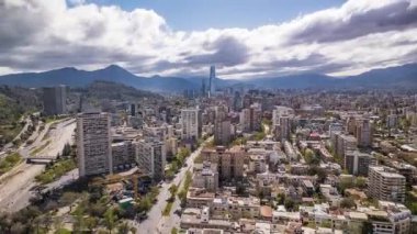 Santiago, Şili 19 Eylül 2024: Providencia bölgesi üzerinde Ufuk çizgisi, Costanera Merkezi ve ilkbaharın başlarında bulutlu gökyüzü olan hava aracı hareketi.