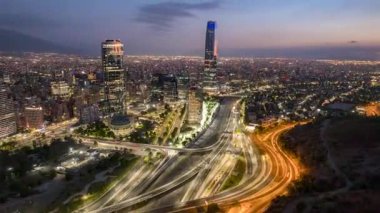 SANTIAGO, / ŞİLİ ŞİMDİ, 21, 2024. İnsansız hava aracı Vitacura, Santiago 'ya yandan iniyor. Şehrin geceye geçişini, ikonik gökdelenleri ve şehir ışıklarını yakalar.
