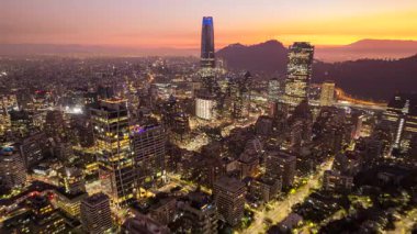 Santiago, Şili 31 Temmuz 2023: İHA gün batımında aydınlık binalar ve Costanera Merkezi üzerinde uçarken şehrin gökyüzü görüntüsü.