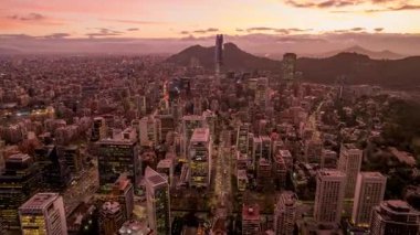 LAS KONUŞU, Şili AĞUSTOS, 10, 2023. Dinamik hiperhız: İHA Santiago 'ya doğru ilerliyor. Gün batımını, Büyük Torre Santiago 'yu ve And Dağları' nı yakalar. Hava kararınca şehrin göz kamaştırıcı manzarası.