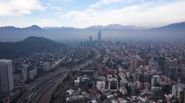 Santiago, Şili 28 Temmuz 2023: Açık bir kış sabahı Costanera Center 'a doğru uçan insansız hava aracı görüntüsü, And Dağları ve arka planda şehir silüeti.