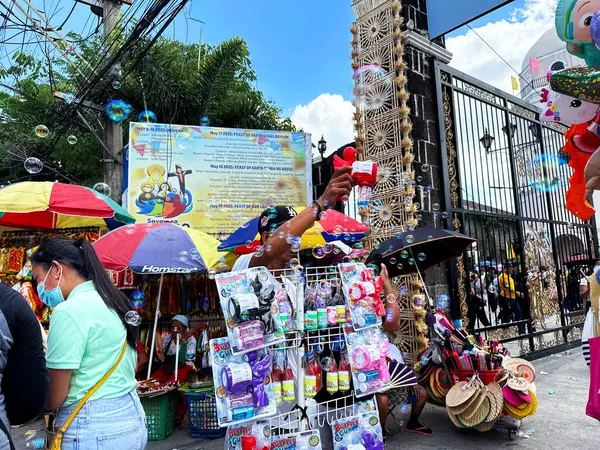 Sokak oyuncakçısı kilisenin önünde baloncuk üflüyor.