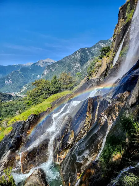 Gökkuşağı ile Alpler 'de nefes kesici bir şelale, doğa, seyahat ve fotoğraf meraklıları için mükemmel.