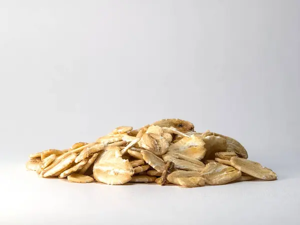 Temiz beyaz arka planda, açık bej dokularını gösteren bir yığın yulaf lapası. Kahvaltı, sağlıklı beslenme ya da pişirme ile ilgili projeler için ideal