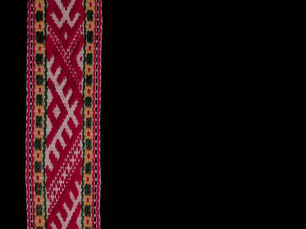 Geleneksel Letonya örgülü bel ve siyah arkaplan üzerine çizilmiş Austras ağaç süslemeleri.