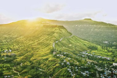 Satara, Maharashtra 'daki Ajinkyatara Kalesi' nden panoramik görüntü, gün doğumunda ele geçirildi. Kale yemyeşil tepelerin tepesinde, kırsal yerleşimlerin altında..