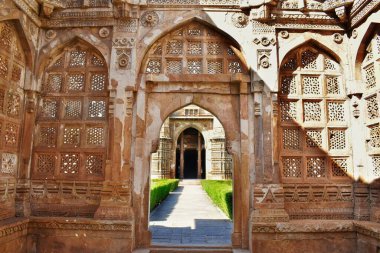 Champaner, Gujarat 'taki Jami Mescid' in karmaşık kuzey tarafı girişi, süslü taş oymalar ve bereketli avluyu çevreleyen, ayrıntılı kafes ve İslami mimari unsurların yer aldığı bir koridor içeriyor..