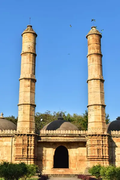 Champaner-Pavagad Arkeoloji Parkı 'ndaki tarihi Saher-ki-Mescid' de, Gujarat açık mavi gökyüzü altında Hint-İslami mimari dehasını yansıtan ikiz taş minareler, karmaşık oymalar ve kubbeler sergiliyor..