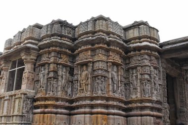 Modhera Güneş Tapınağı 'ndaki Gudhamandapa' nın dış duvarlarında, Hindu tanrılarının detaylı taş oymaları, karmaşık sanat ve kültür mirası sergilenmektedir..