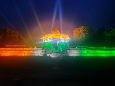 Üç renkli ışıklandırma Surya Kund 'un suyunda çarpıcı bir yansıma yaratarak gece Modhera Güneş Tapınağı' nın güzelliğini ve kutsallığını arttırır..