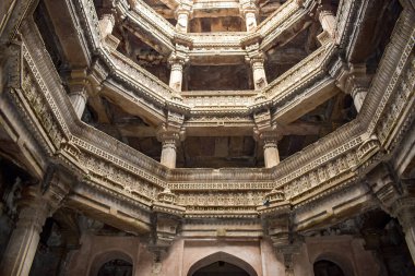 Ahmedabad, Gujarat 'ta tarihi bir basamak olan Adalaj Ni Vav, karmaşık taş oymaları, simetrik katlar ve kemerleri vurguluyor. Merkezi görünümde mimari ihtişamı ve kültürel önemi gözler önüne seriliyor.