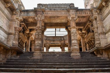 Görüntü, Ahmedabad, Gujarat 'taki Adalaj ni Vav Stepwell' in taş sütunlarına, karmaşık tasarımlarına ve simetrik düzenine odaklanan mimari özelliklerini sergiliyor..