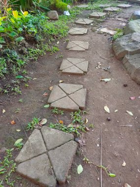 Keşif Yolu: Kırsal basamak taşları yeşil yaprakların arasına barışçıl bir yolculuk yaparak doğal bir bahçeye giden yolu gösteriyor..