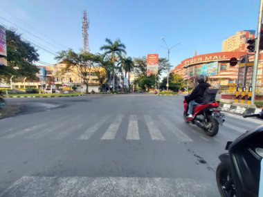 Endonezya şehir caddesinin dinamik akışını yakalamak, çok sayıda motosiklet ve aracın büyük bir kavşakta yol alması, şehir hayatının nabzını yansıtıyor..