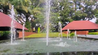 Malang, Doğu Java, Endonezya 'da, yemyeşil ve geleneksel pavyonlar arasında canlı bir su çeşmesinin yer aldığı sakin bir manzara. Malang Doğu Java, Brawijaya Üniversitesi. 22 Haziran 2025