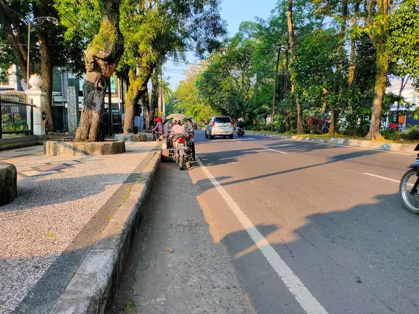 Shaded Street Scene: Malang 'da günlük iş çıkışı. Malang, Doğu Java. 21 Haziran 2025
