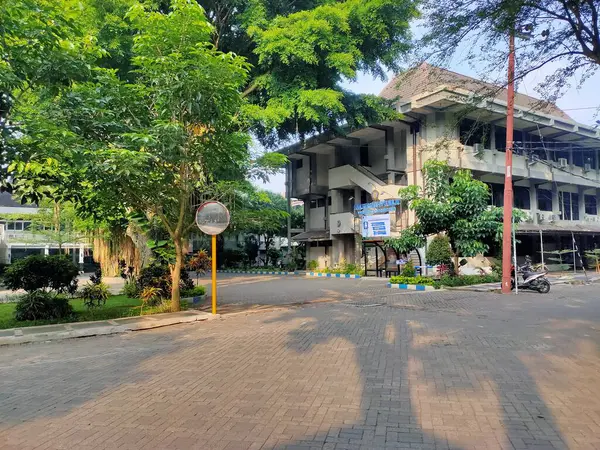Binaları ve bereketli ağaçları olan kampüs yolu. Brawijaya Üniversitesi, Malang, Doğu Java. 22 Haziran 2025