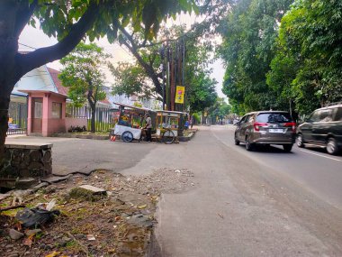Tekerlekli arabası olan bir sokak satıcısı, Malang, Doğu Cava 'da yol kenarında duruyor ve yerel küçük işletmeleri ve toplumdaki günlük yaşamı gözler önüne seriyor. Malang, Doğu Java. 24 Haziran 2025