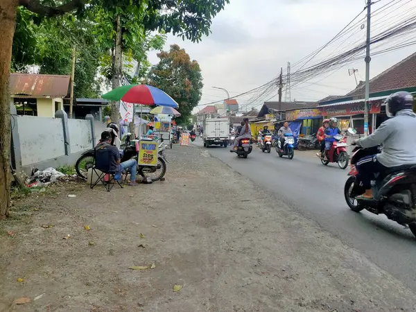 Tekerlekli arabası olan bir sokak satıcısı, Malang, Doğu Cava 'da yol kenarında duruyor ve yerel küçük işletmeleri ve toplumdaki günlük yaşamı gözler önüne seriyor. Malang, Doğu Java. 24 Haziran 2025