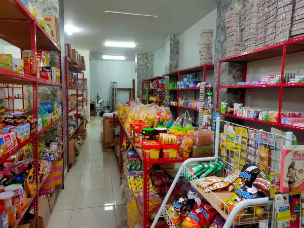 Endonezya 'nın küçük, geleneksel bir bakkalında çeşitli paketlerle dolu canlı raflar, günlük ihtiyaçlar ve yerel ürünler sergileniyor. Malang, Doğu Java. 25 Haziran 2025