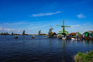 Geleneksel yel değirmenleri, ahşap evler ve Amsterdam yakınlarındaki tarihi bir Hollanda köyü olan Zaanse Schans 'taki manzaralı kanalların görüntüleri. Bu açık hava müzesi alanı otantik 18. ve 19. yüzyıl mimarisini, güzel manzaraları sergiliyor.